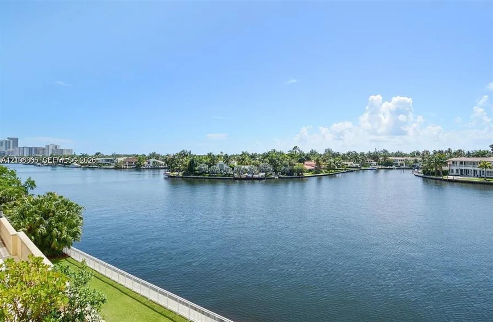 Waterfront perspective featuring a wide canal, bulkhead seawall, and landscaped perimeter