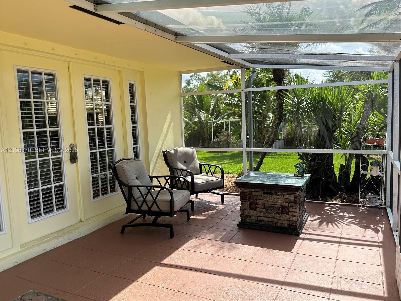 Screened-in porch featuring a tile floor, glass-paneled entry doors, and a transparent roof covering