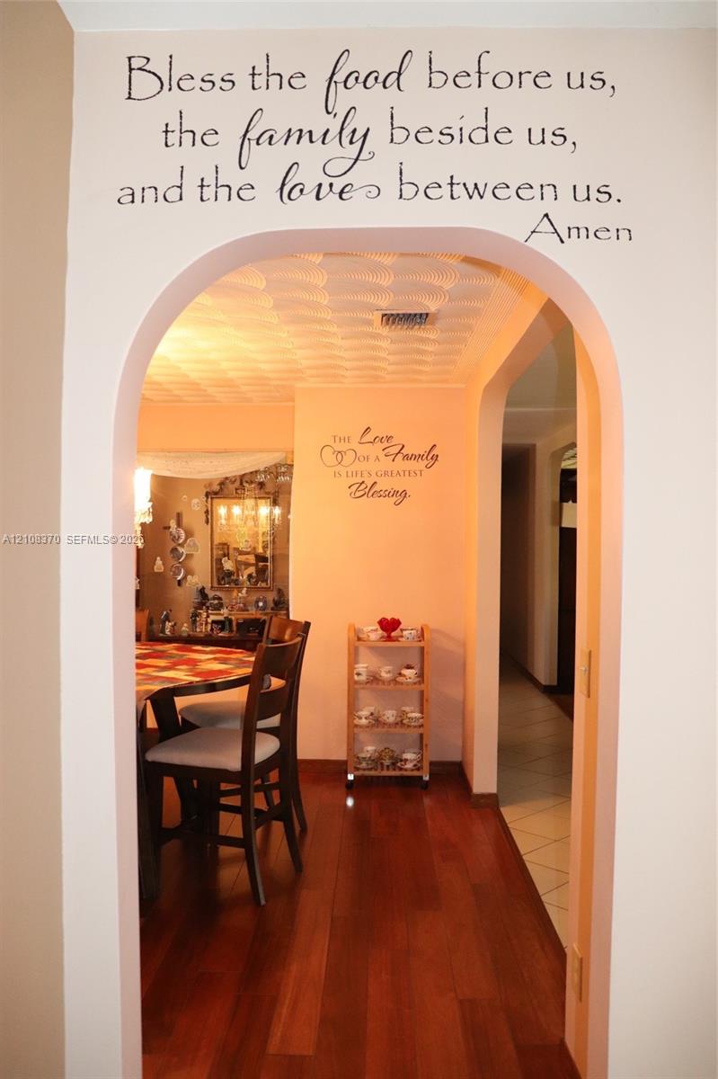 Architectural arched doorway featuring wood-finish flooring and textured ceiling detail