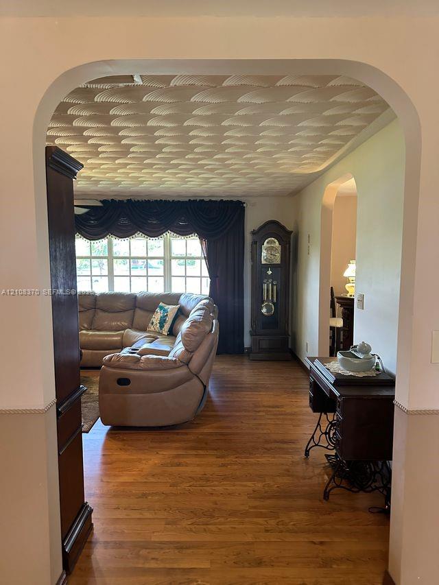 Arched doorways, wood-finish flooring, and textured decorative ceiling