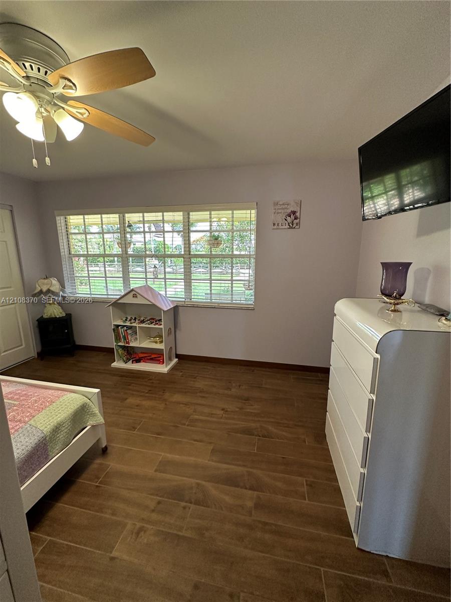 Wood-finish flooring, multi-pane windows, and a multi-light ceiling fan with integrated illumination