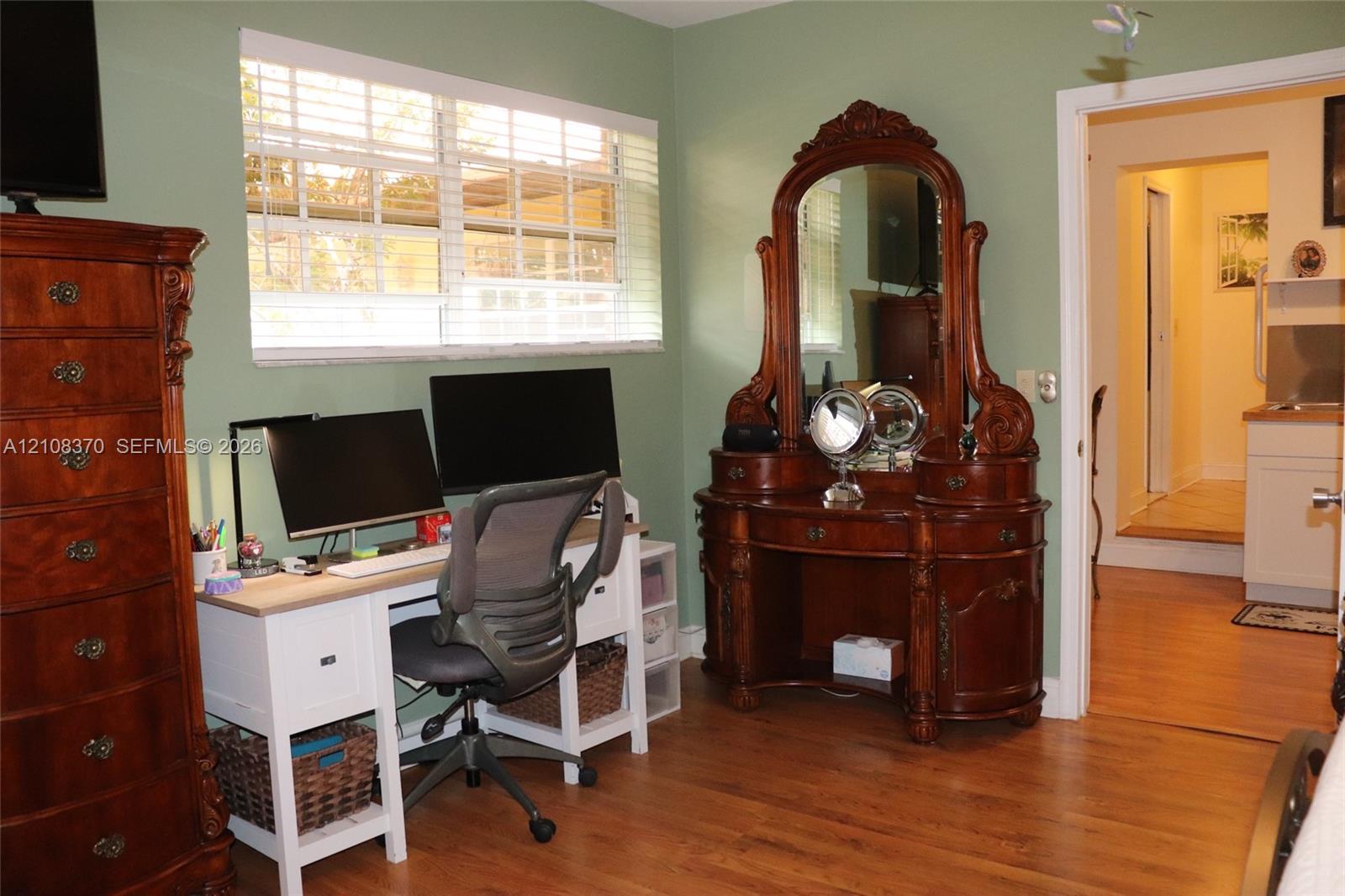 Room featuring wood-finish flooring and a horizontal window with slatted blinds