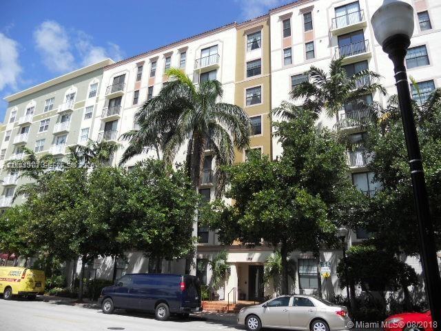 Multi-story residential building exterior featuring stucco facade, recessed balconies, and articulated architectural detailing