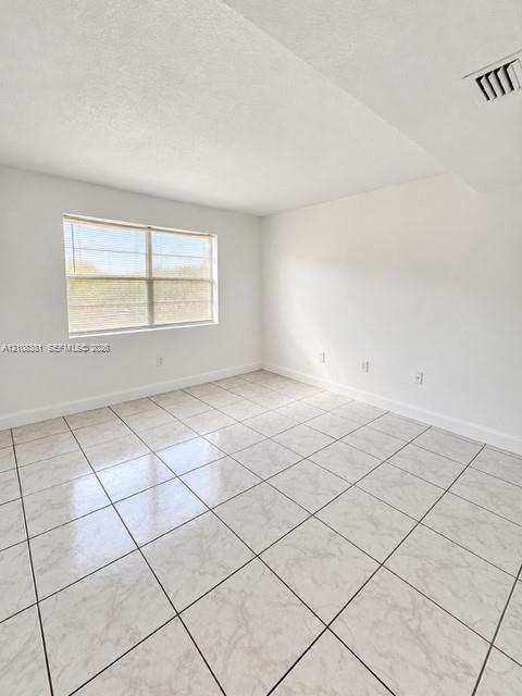 Walk-in closet featuring ceramic tile flooring, dual-level wire shelving, and a flush-mount ceiling light fixture