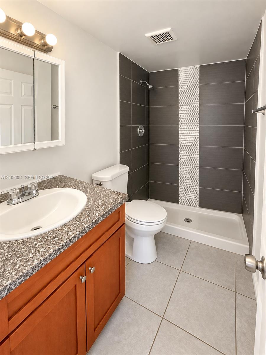 Neutral tile flooring, dual reach-in closets with six-panel doors, and a double-hung window with integrated blinds