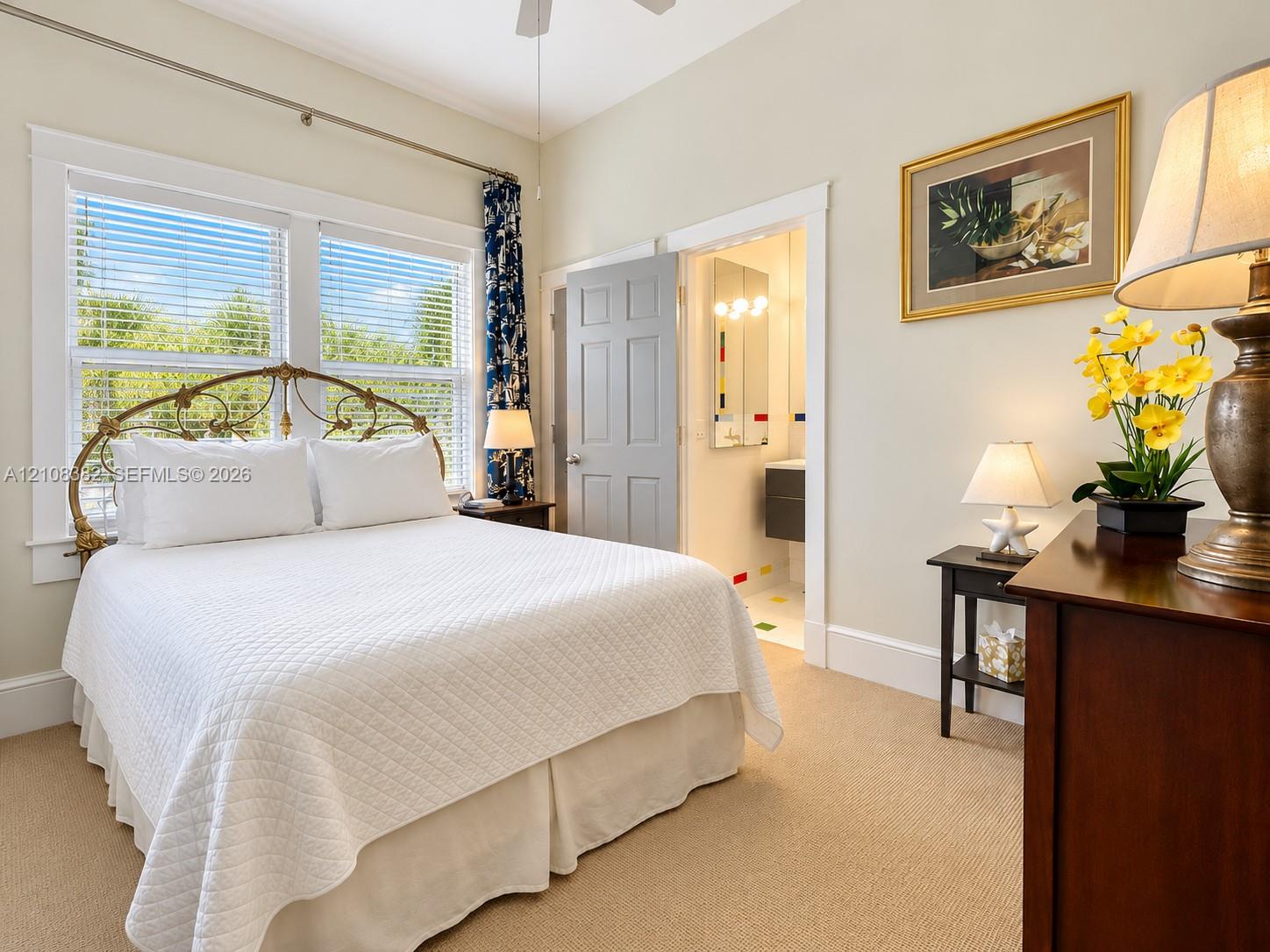 Bedroom featuring neutral wall color, plush carpeting, high ceilings with a mounted fan, and large windows with multi-pane glass Bedroom featuring neutral wall color, plush carpeting, high ceilings with a mounted fan, and large windows with multi-pane glass