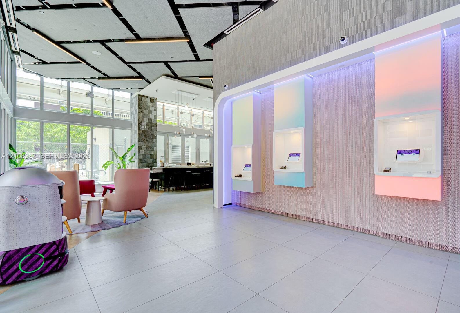 Large-format tile flooring, geometrically patterned ceiling grid, floor-to-ceiling windows, and recessed illuminated wall displays