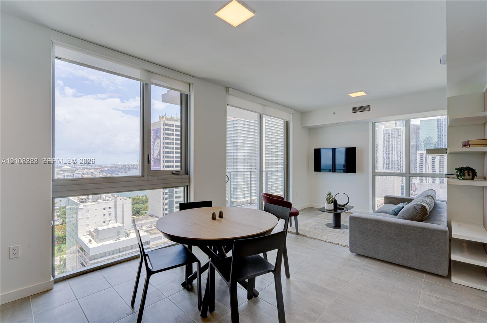 Floor-to-ceiling windows, tile flooring, built-in shelving, and balcony access Floor-to-ceiling windows, tile flooring, built-in shelving, and balcony access