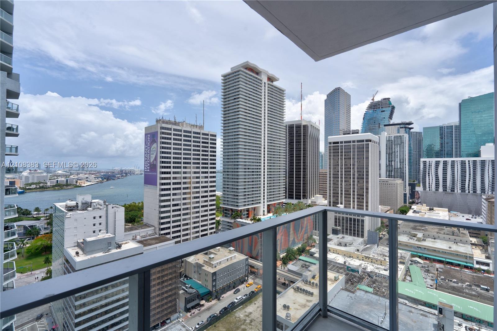 Covered balcony with glass and metal railings overlooking the urban skyline and waterway Covered balcony with glass and metal railings overlooking the urban skyline and waterway