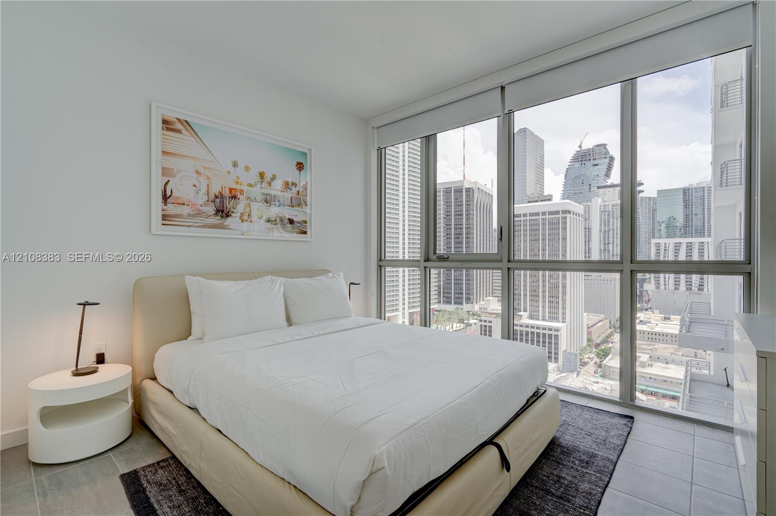 Floor-to-ceiling windows featuring urban skyline exposure and neutral-tone tile flooring Floor-to-ceiling windows featuring urban skyline exposure and neutral-tone tile flooring