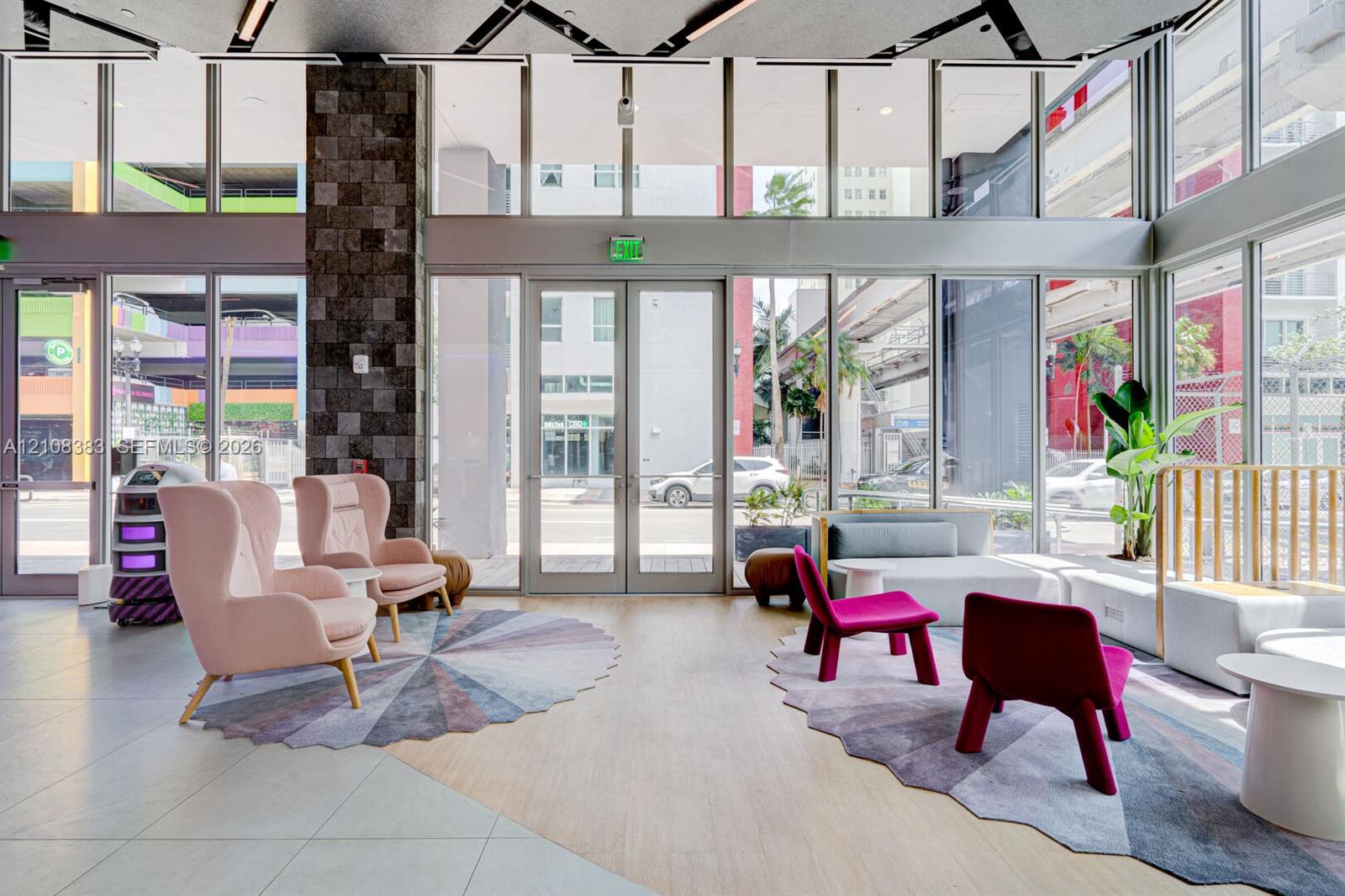 Floor-to-ceiling glass windows, textured stone-veneer accent column, neutral tile flooring, and integrated linear ceiling lighting