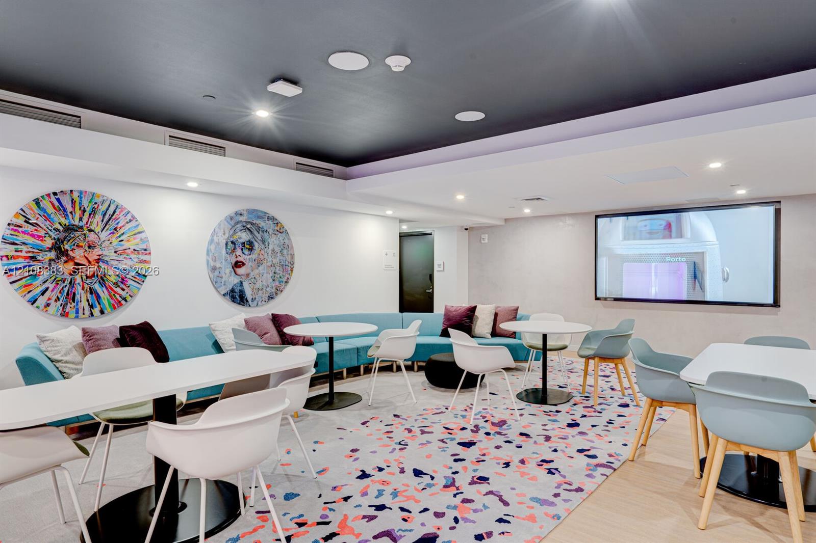 Common area featuring a recessed ceiling with integrated lighting, recessed wall display, and patterned flooring