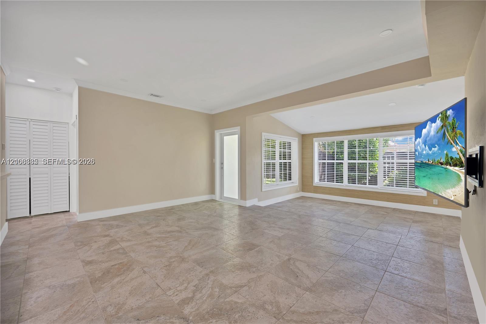 Neutral tile flooring, recessed lighting, crown molding, multi-pane windows, and white louvered closet doors Neutral tile flooring, recessed lighting, crown molding, multi-pane windows, and white louvered closet doors