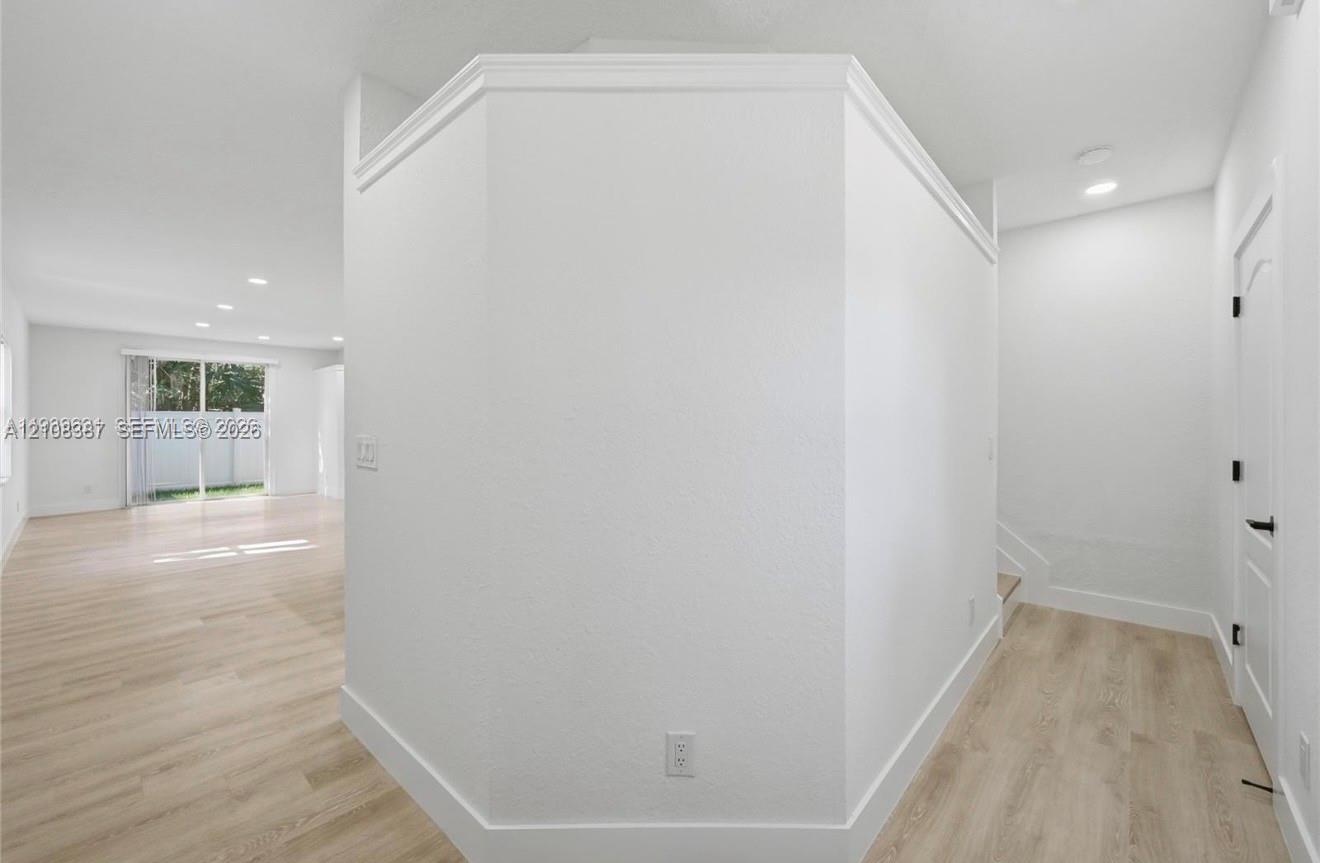 Interior featuring wood-finish flooring, recessed lighting, and a prominent hexagonal wall partition