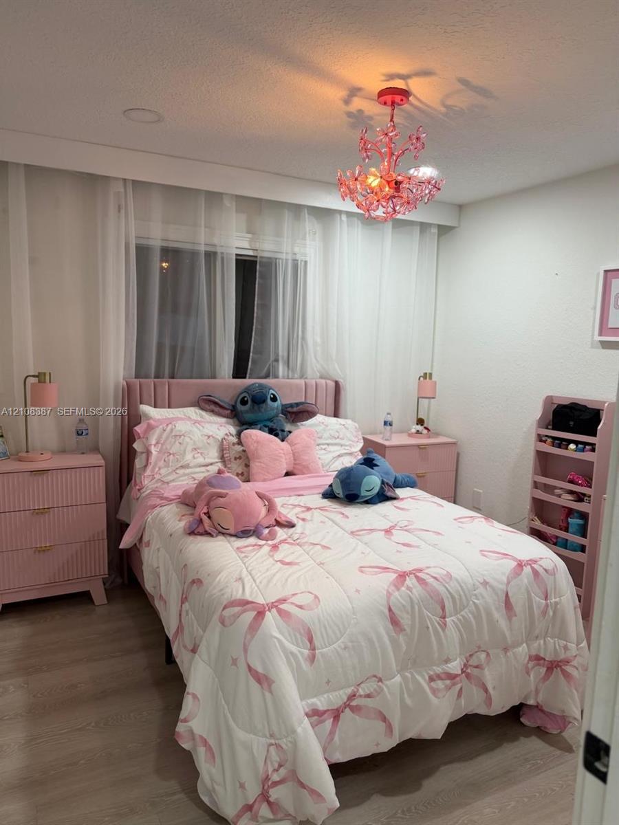 Recessed lighting, ornate multi-arm chandelier, and wood-finish flooring