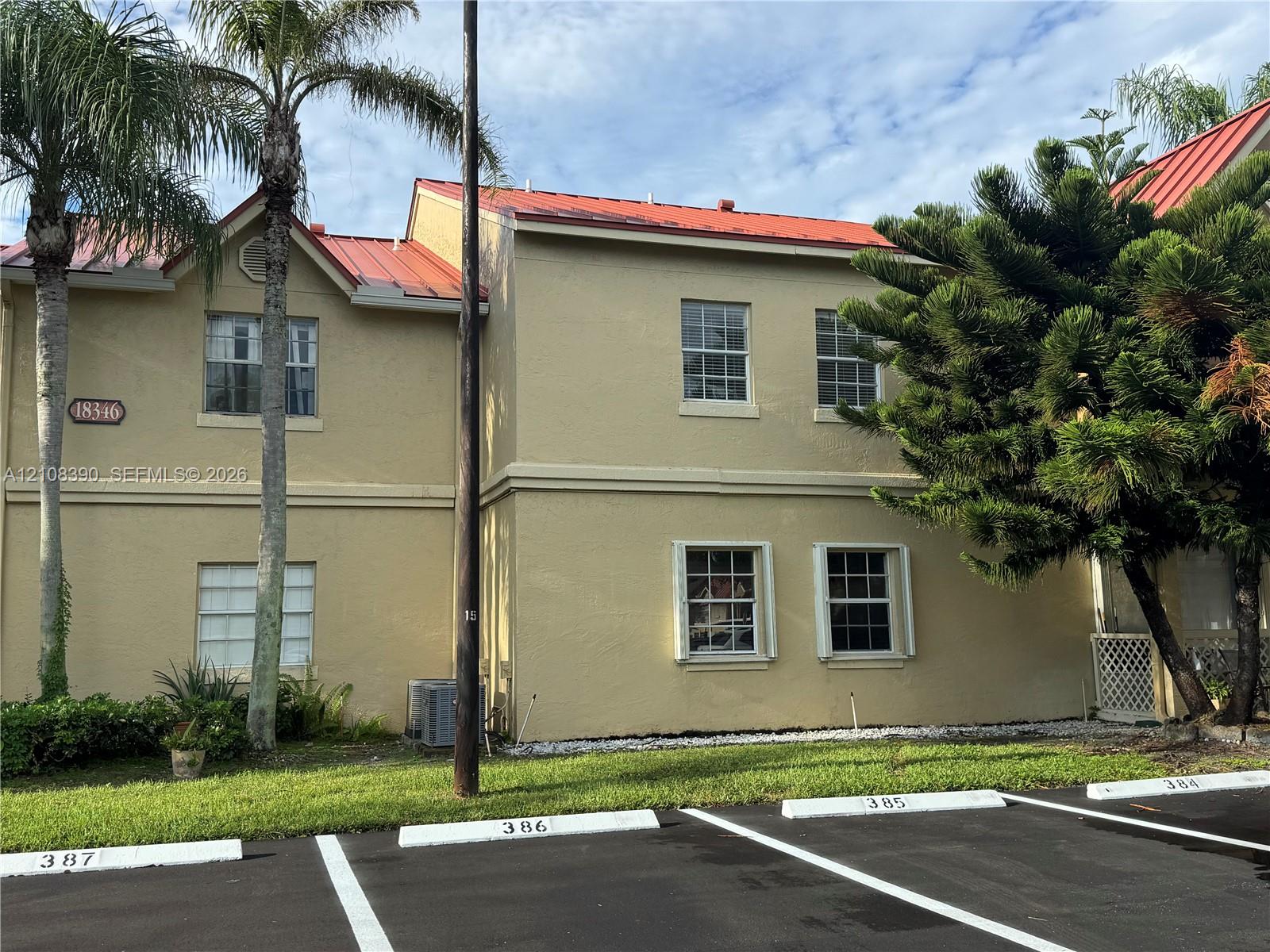Two-story exterior featuring a metal roof, stucco siding, and double-hung windows Two-story exterior featuring a metal roof, stucco siding, and double-hung windows