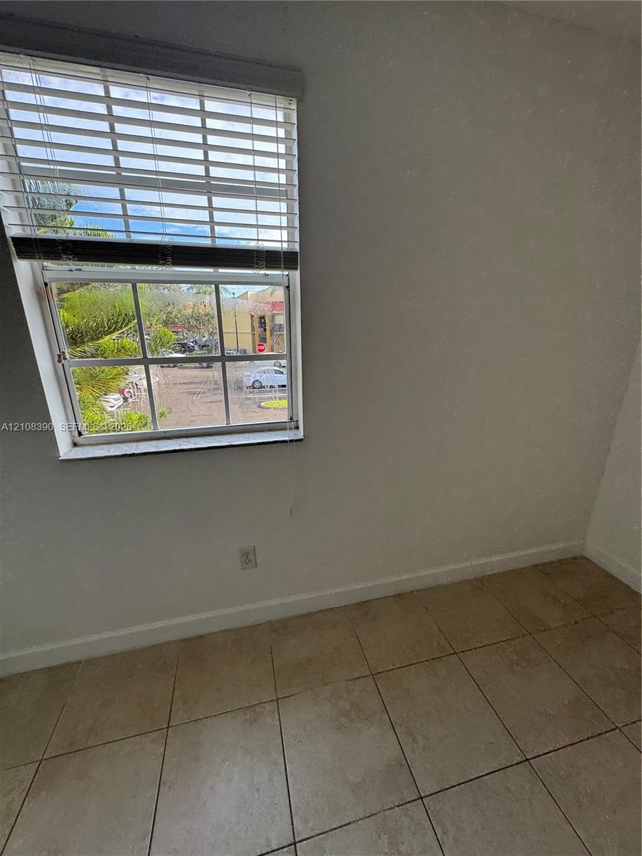 Multi-pane window featuring horizontal blinds and neutral-toned tile flooring