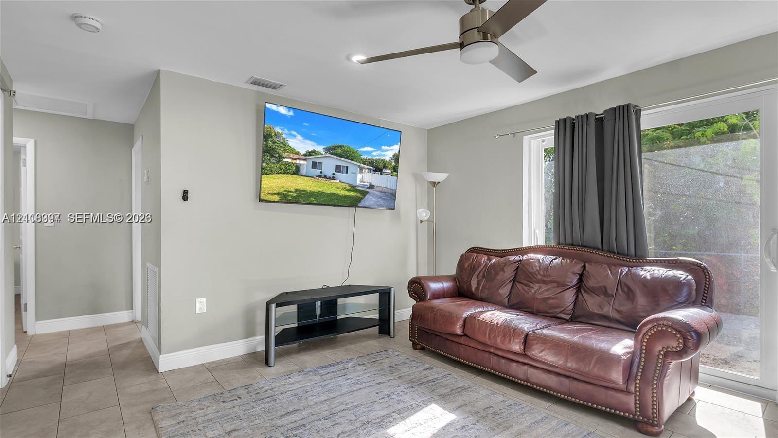 Neutral-toned walls, tile flooring, and a ceiling fan with integrated lighting