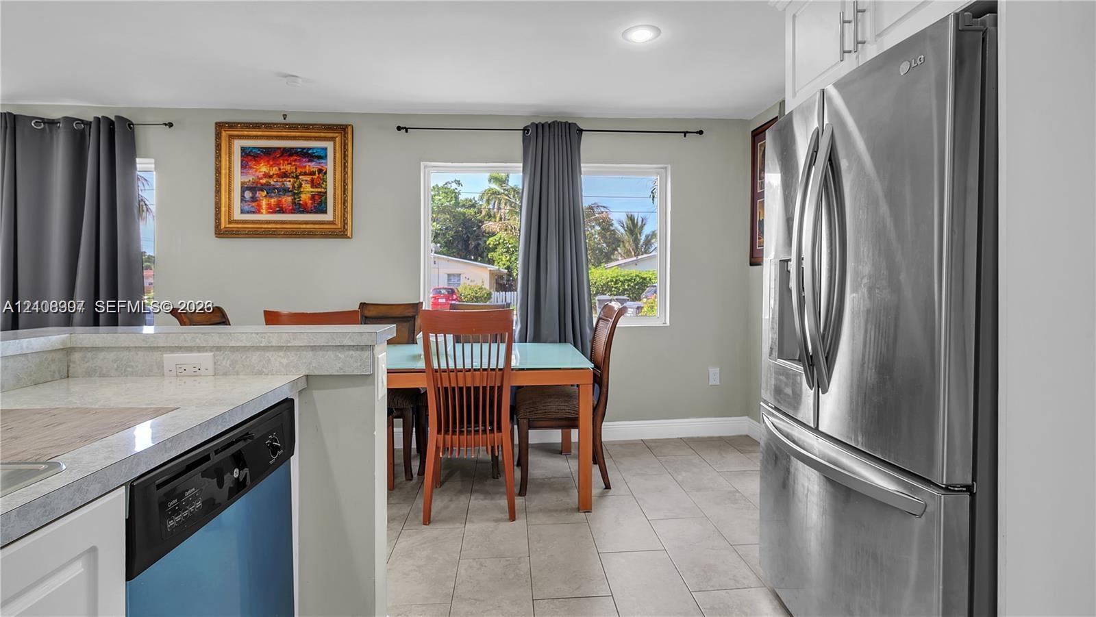 Stainless steel French-door refrigerator, stone-composite countertops, recessed lighting, and ceramic tile flooring