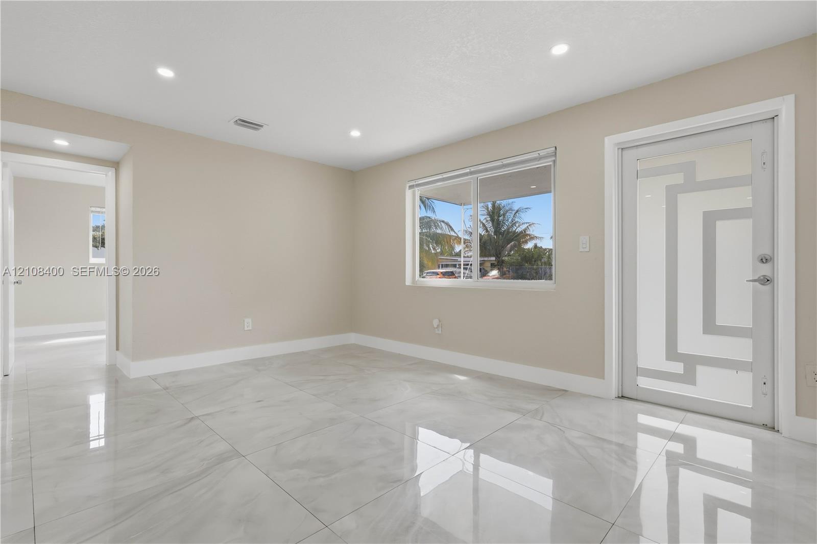 Polished stone-finish flooring, recessed ceiling lighting, and exterior door with decorative glass insert Polished stone-finish flooring, recessed ceiling lighting, and exterior door with decorative glass insert