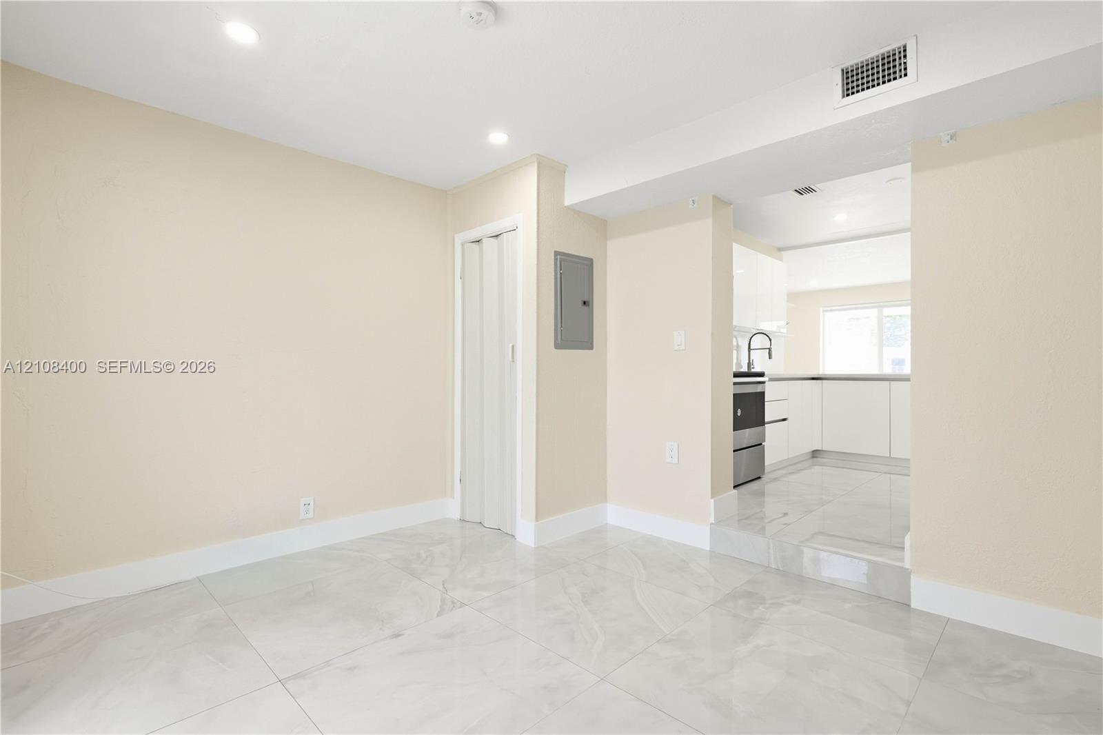 Interior space featuring polished stone-finish tile flooring, recessed ceiling lighting, and a neutral color palette