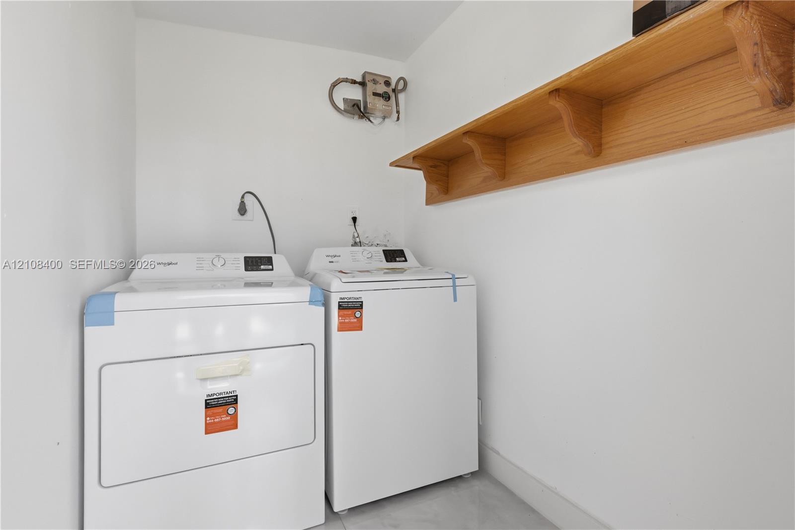 Dedicated utility space featuring a wall-mounted wood-finish shelving unit