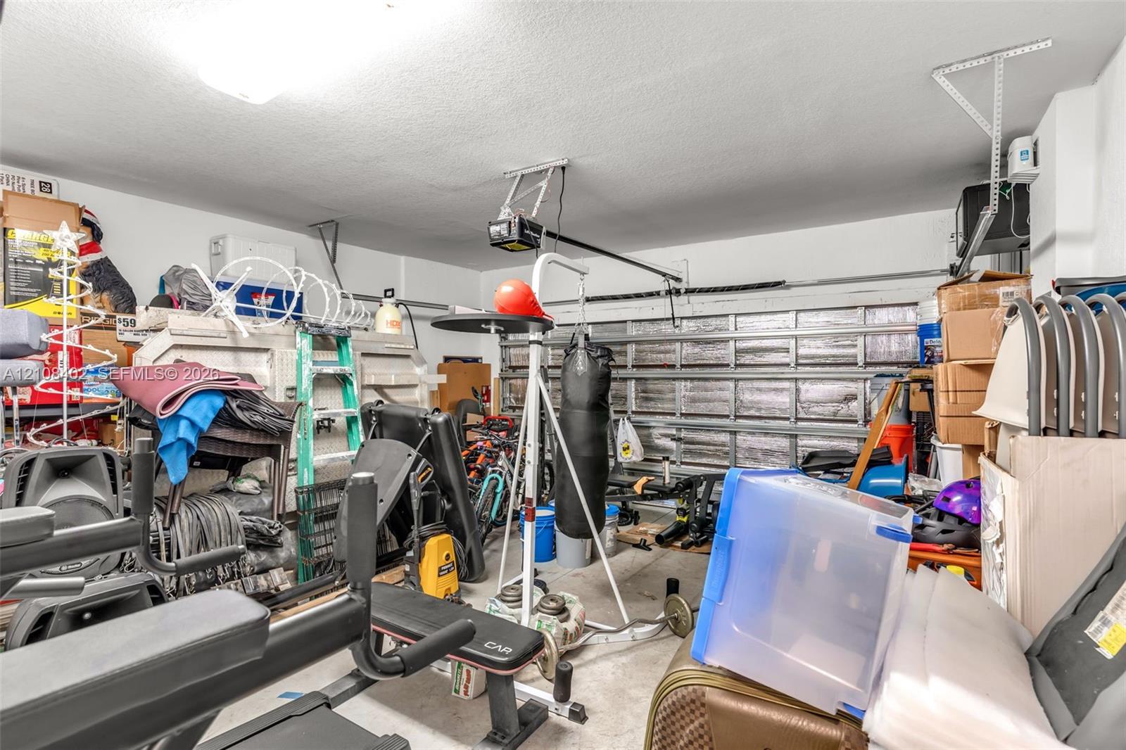 Garage space featuring a metal sectional overhead door and an installed motorized door opener