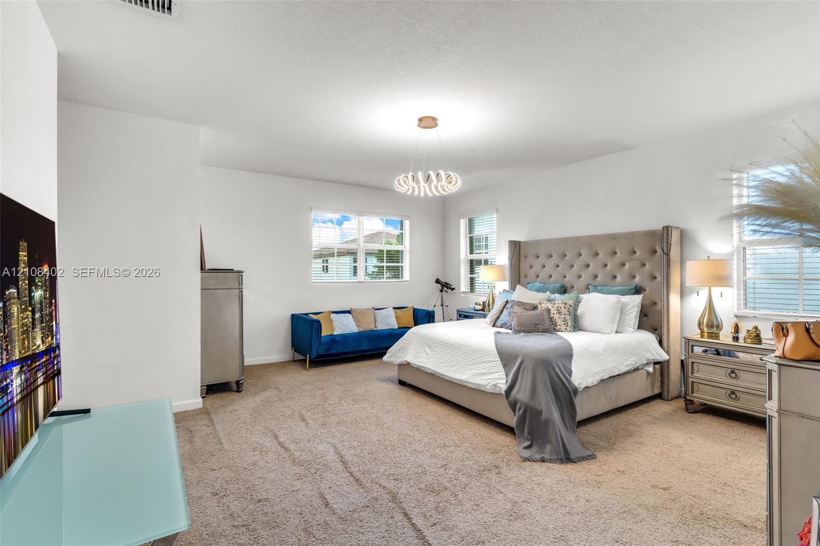 Neutral wall finishes, plush carpeting, multi-pane windows, and a sculptural modern ceiling light fixture