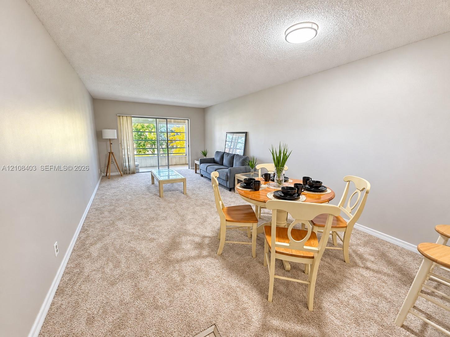 Neutral-toned carpeted flooring, flush-mount ceiling lighting, and glass sliding doors providing exterior access Neutral-toned carpeted flooring, flush-mount ceiling lighting, and glass sliding doors providing exterior access