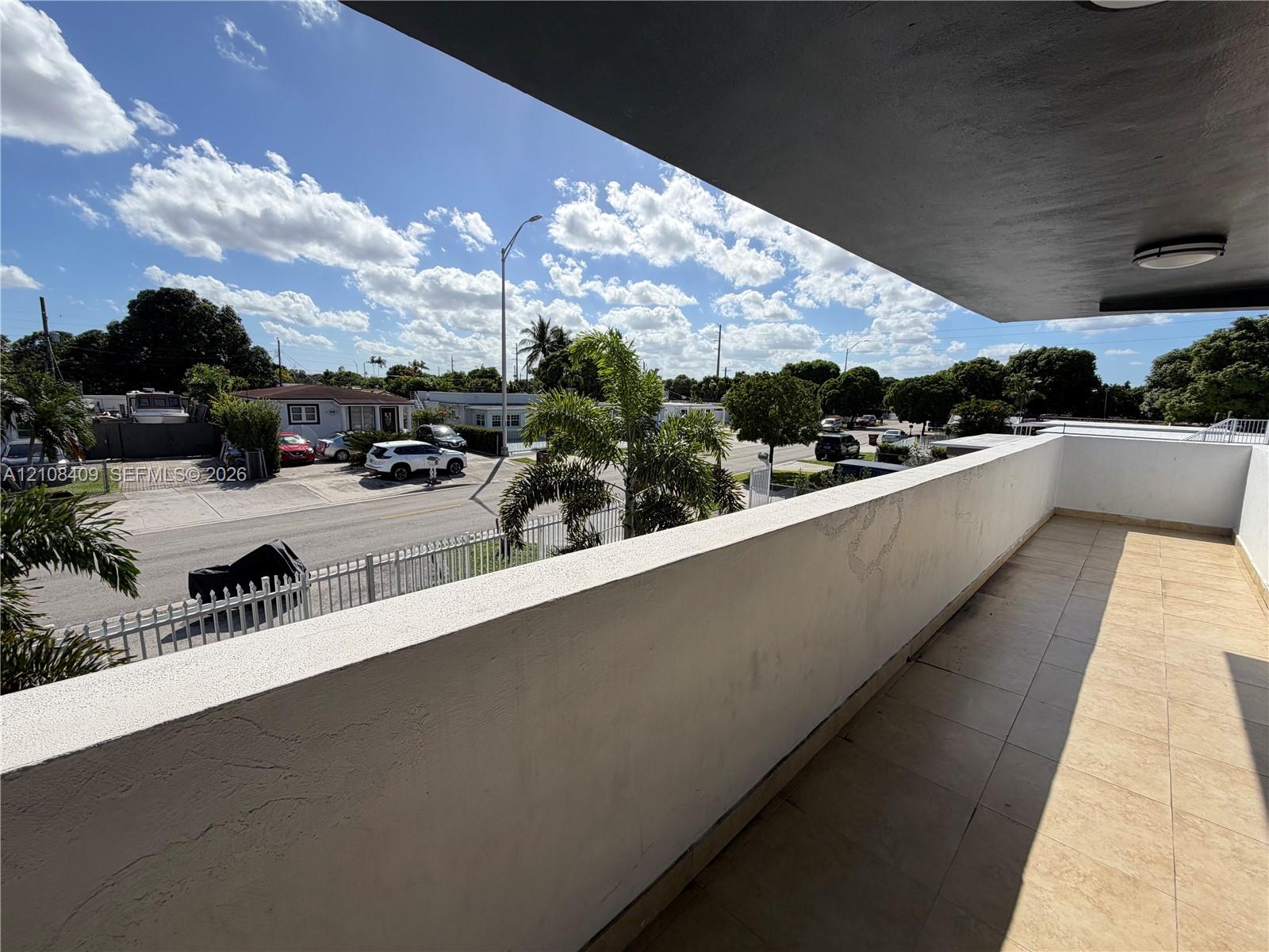 Covered balcony featuring tile flooring and a concrete privacy wall