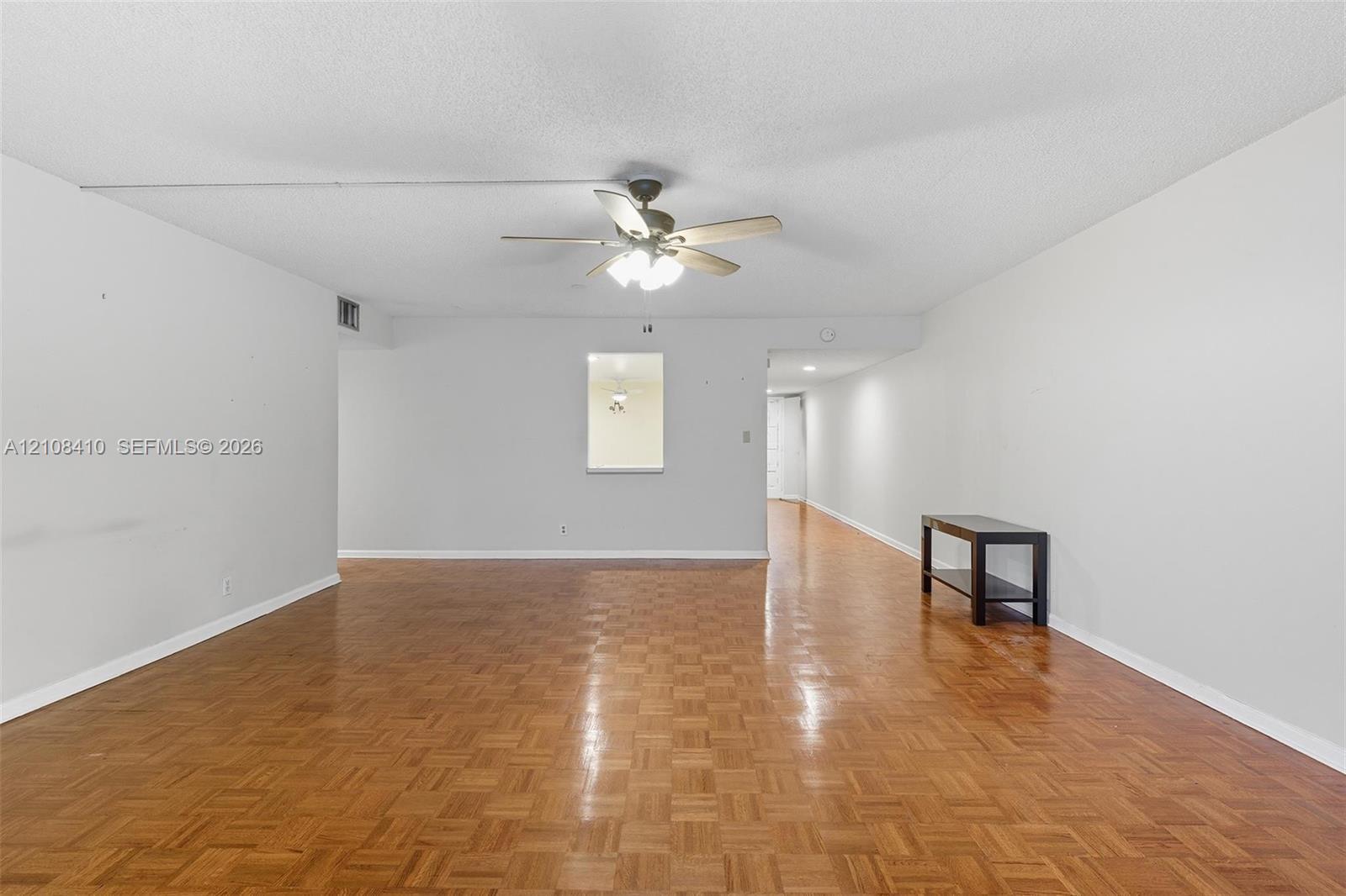 Parquet wood-finish flooring, ceiling fan with integrated light fixture, and interior pass-through opening Parquet wood-finish flooring, ceiling fan with integrated light fixture, and interior pass-through opening