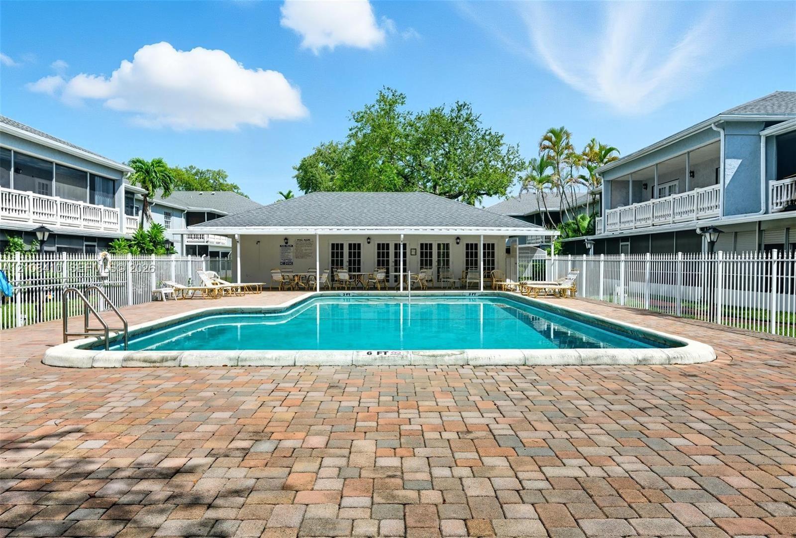 Swimming pool with paver decking and white perimeter fencing