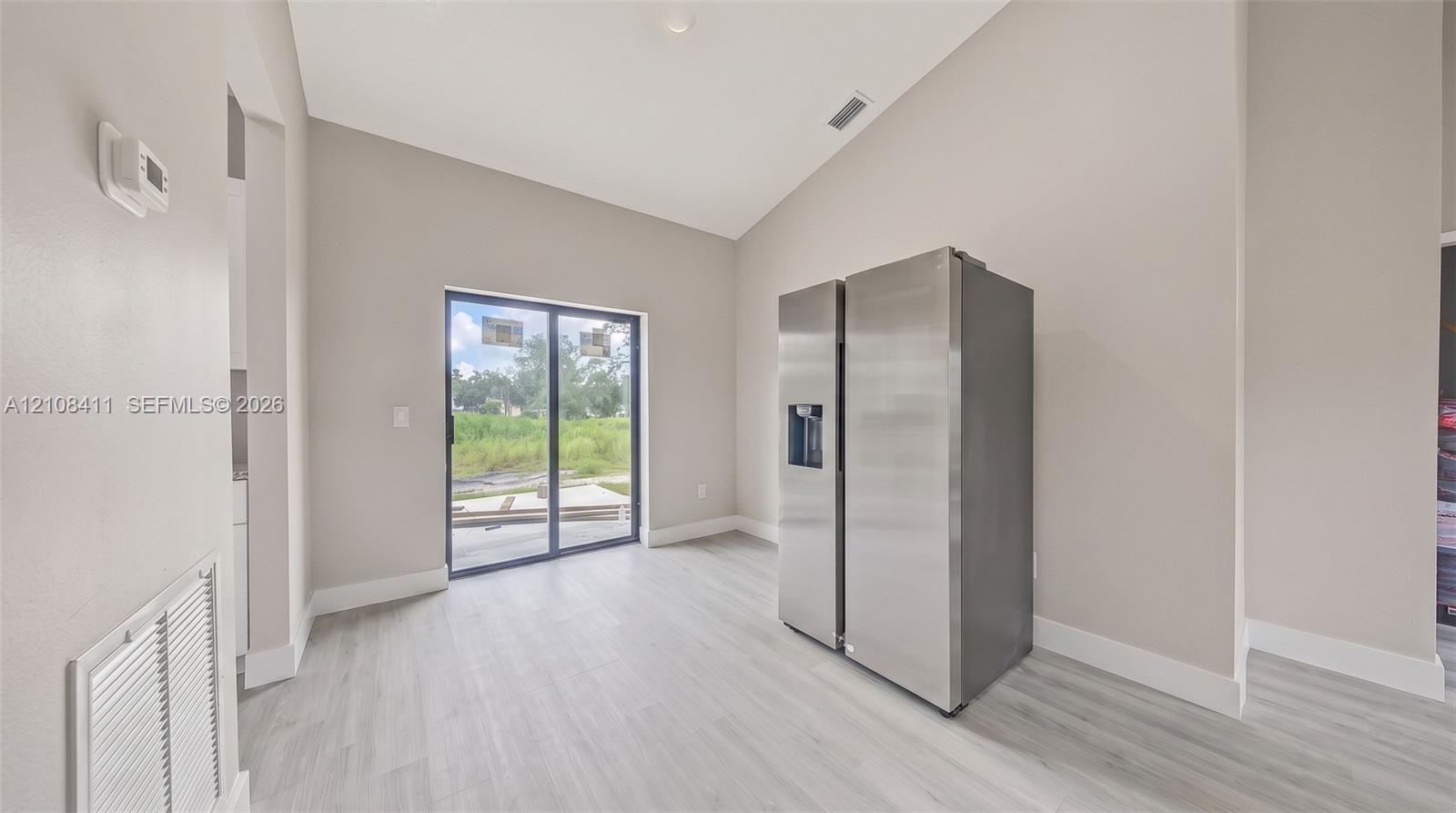 Vaulted ceilings, wood-finish flooring, and sliding glass doors providing natural light