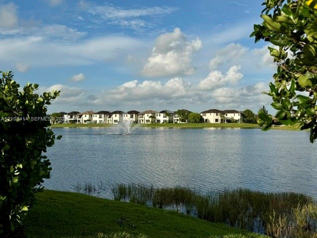 Waterfront setting featuring a central lake fountain and landscaped shoreline