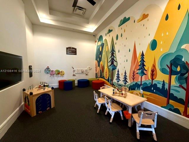 Interior space featuring a recessed tray ceiling and a large-scale decorative mural on the primary wall