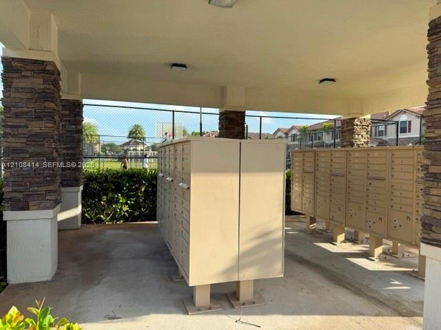 Covered mail kiosk featuring stacked-stone masonry columns and integrated ceiling lighting