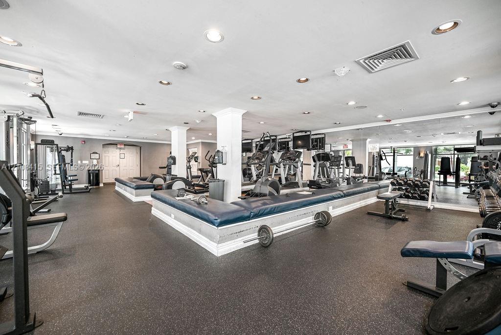 Fitness space featuring rubberized flooring, recessed lighting, and wall-to-wall mirrors