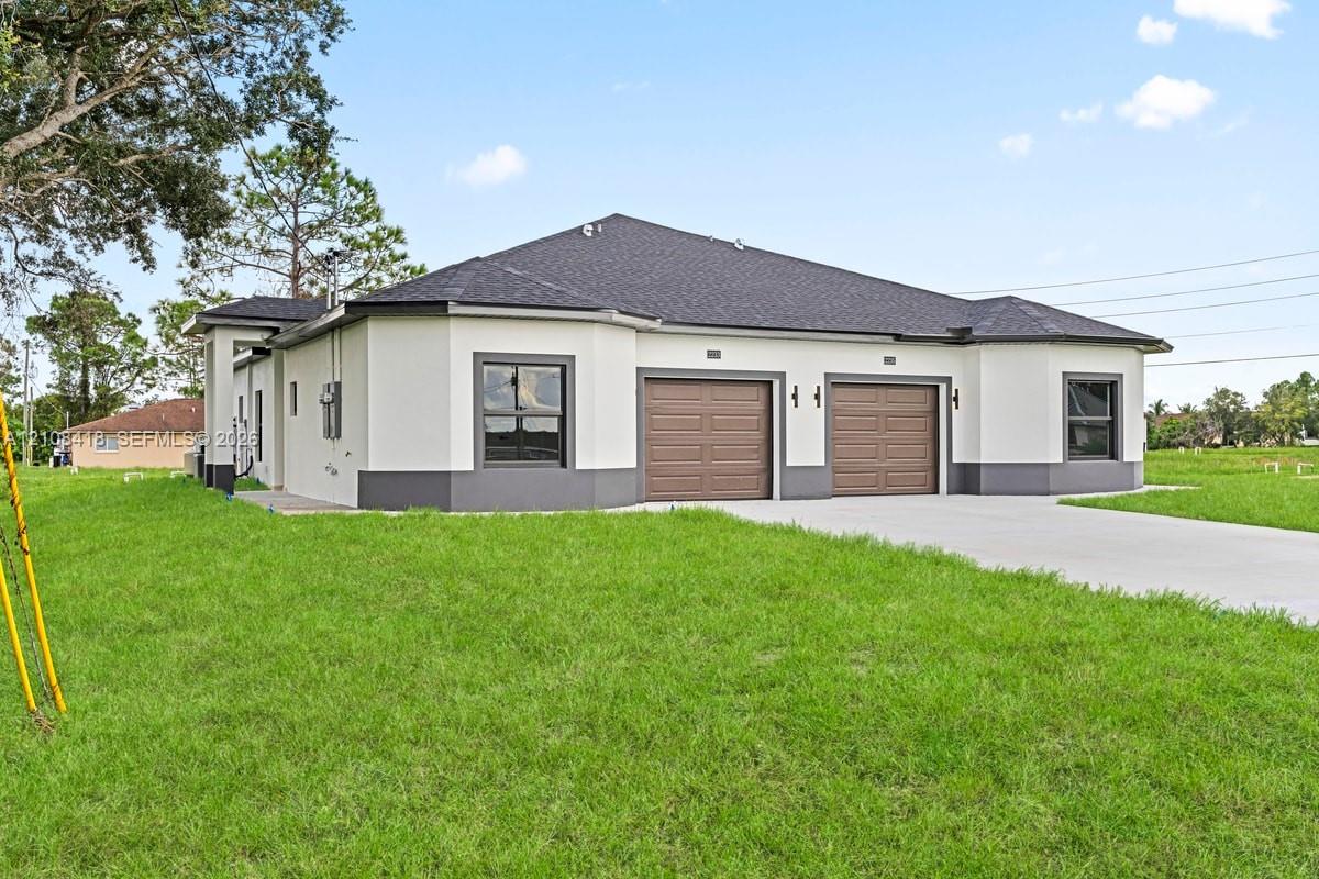 Stucco exterior featuring dual-bay garage doors, a concrete driveway, multi-faceted roofline, and trimmed windows Stucco exterior featuring dual-bay garage doors, a concrete driveway, multi-faceted roofline, and trimmed windows