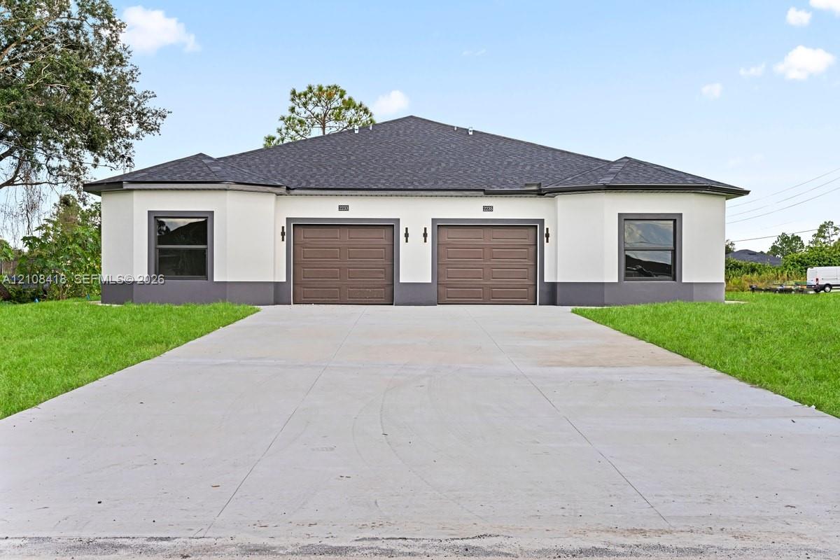 Stucco exterior with contrasting trim, dual garages, asphalt shingle roof, and a paved concrete driveway Stucco exterior with contrasting trim, dual garages, asphalt shingle roof, and a paved concrete driveway