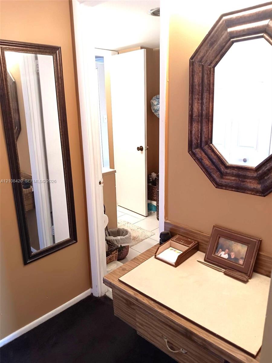 Built-in wood vanity featuring a flat-surface countertop, an octagonal wall-mounted mirror, and a full-length rectangular wall-mounted mirror