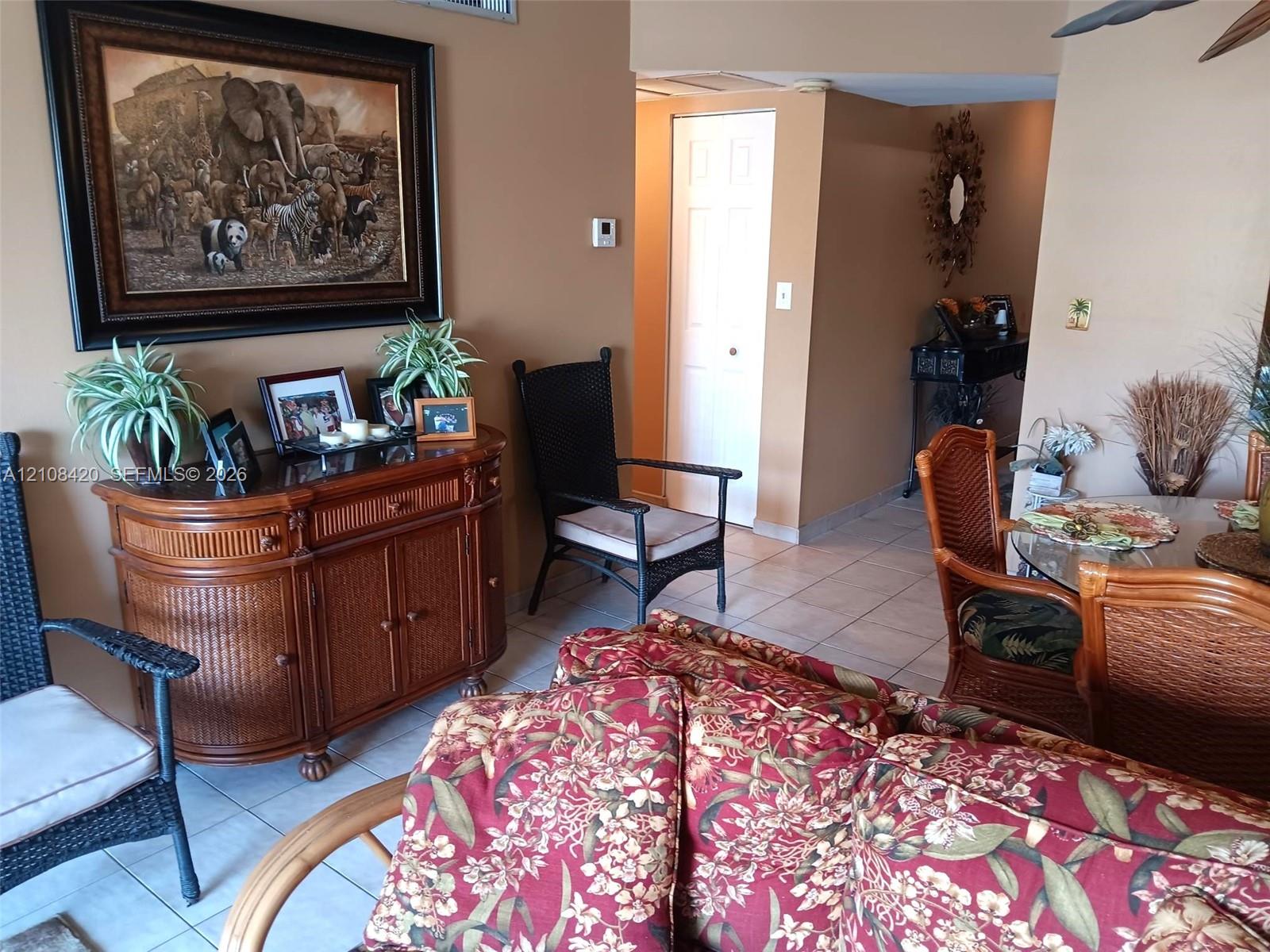 Interior space featuring neutral-toned walls, tile flooring, and a six-panel interior door Interior space featuring neutral-toned walls, tile flooring, and a six-panel interior door