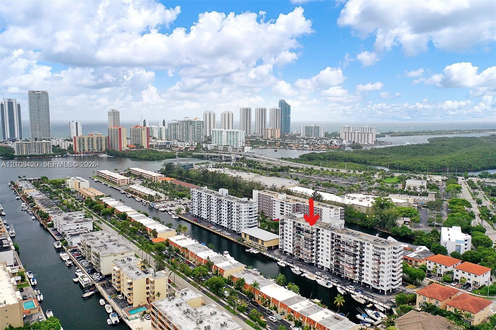 Aerial perspective of a high-rise residential building featuring waterfront positioning, private balconies, and proximity to coastal waterways Aerial perspective of a high-rise residential building featuring waterfront positioning, private balconies, and proximity to coastal waterways
