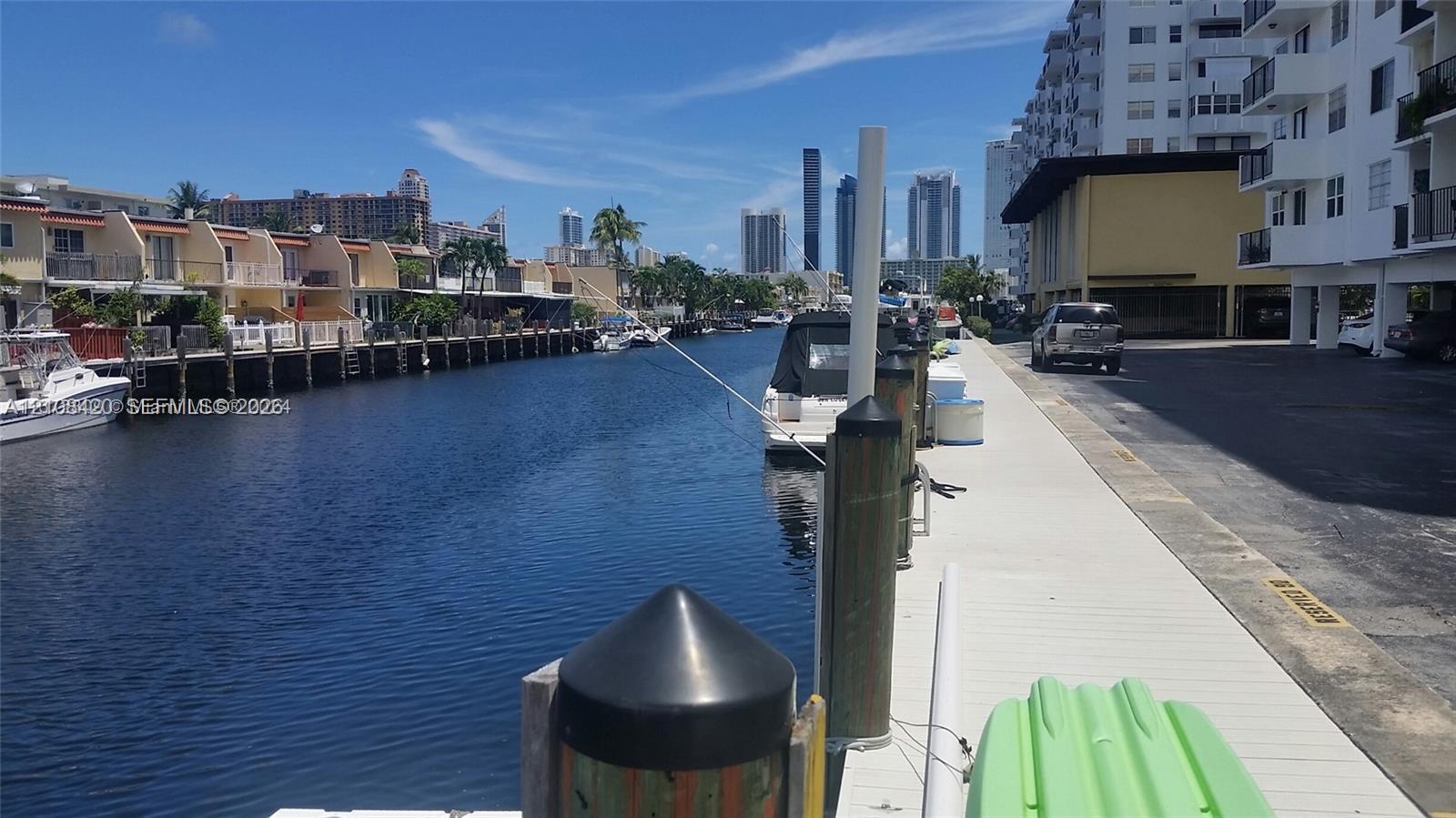 Waterfront canal bulkhead featuring dock pilings and concrete walkway