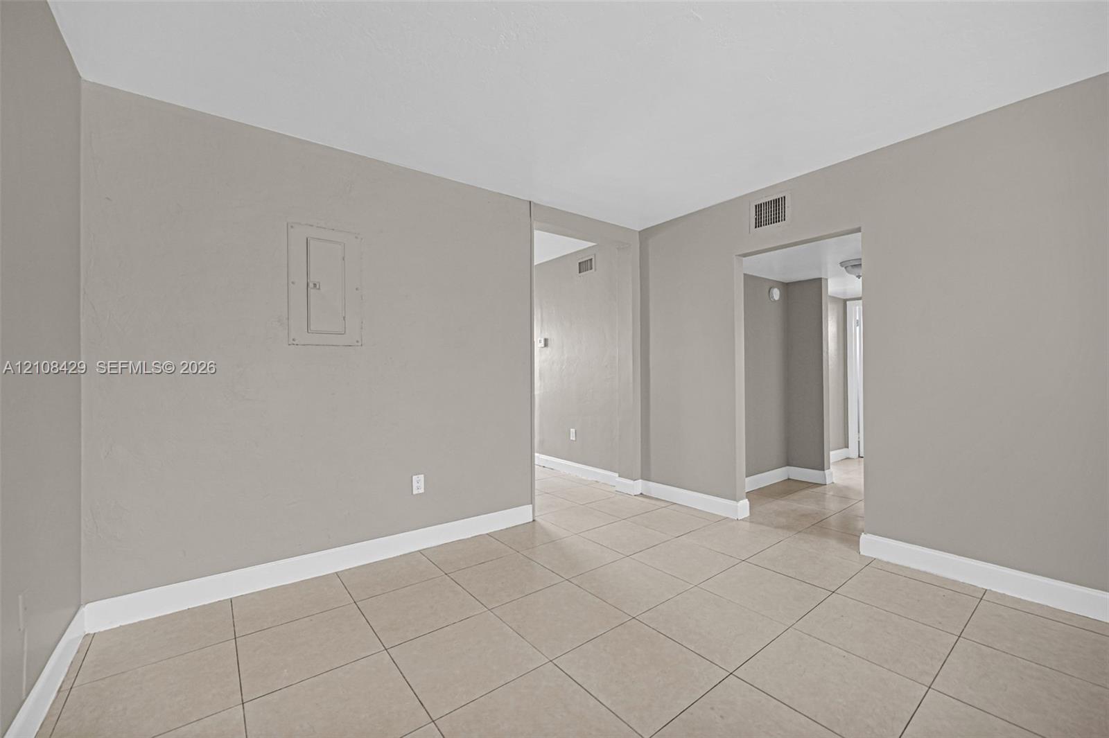 Interior space featuring neutral-toned walls, tile flooring, and recessed doorway openings