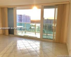 Floor-to-ceiling sliding glass doors, private glass-railed balcony, and large-format tile flooring Floor-to-ceiling sliding glass doors, private glass-railed balcony, and large-format tile flooring