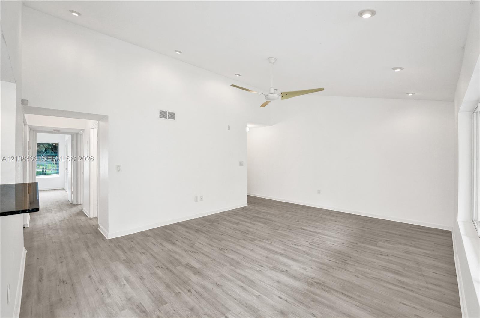 Vaulted ceilings featuring recessed lighting, a modern ceiling fan, and wood-finish flooring