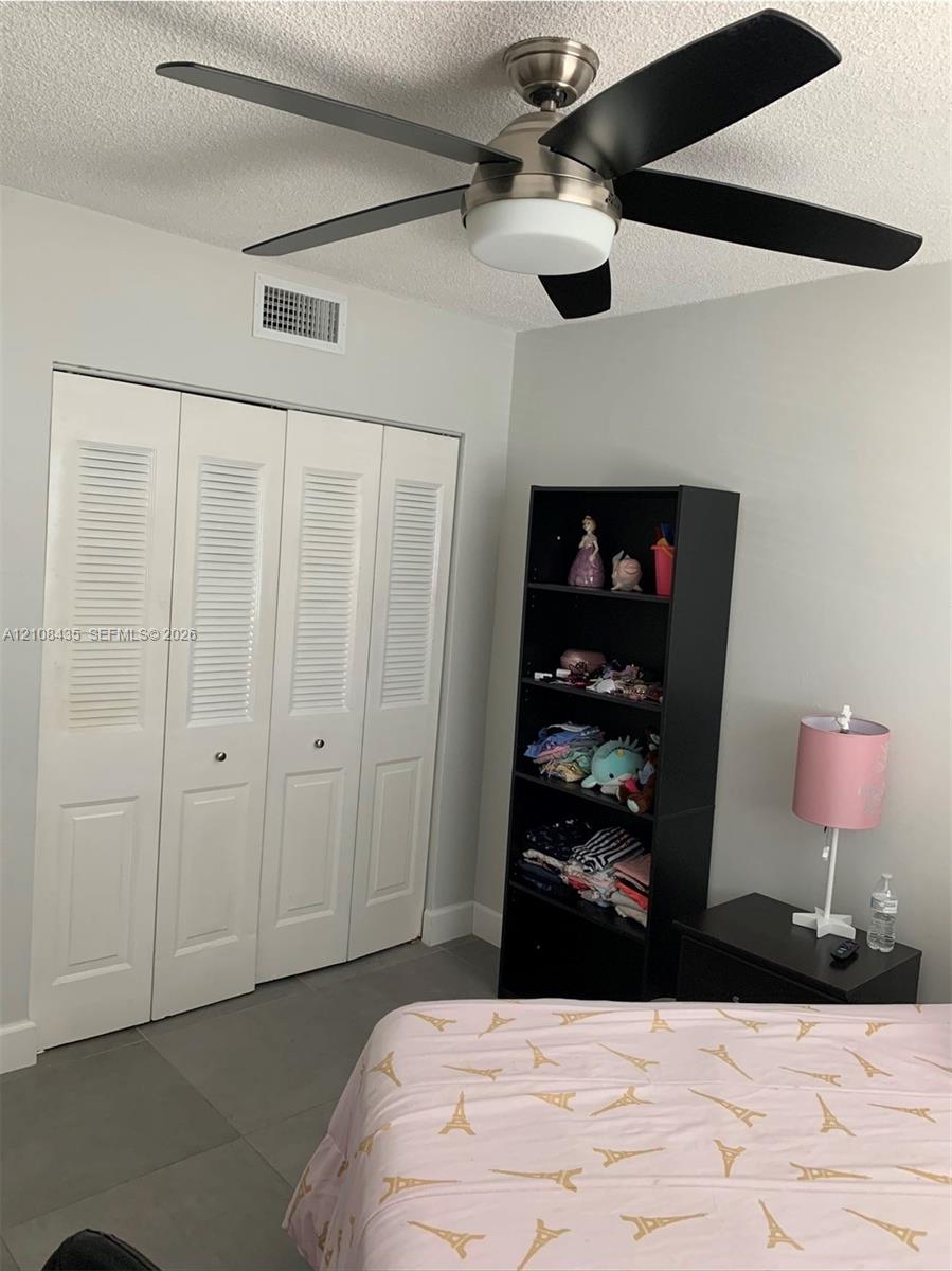 Brushed nickel ceiling fan with matte black blades and integrated light fixture, paired with four-panel louvered closet doors