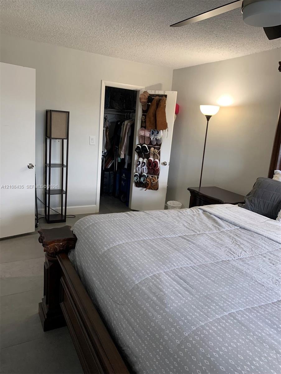 Room featuring neutral wall paint, solid-core interior doors, and a ceiling fan with integrated lighting
