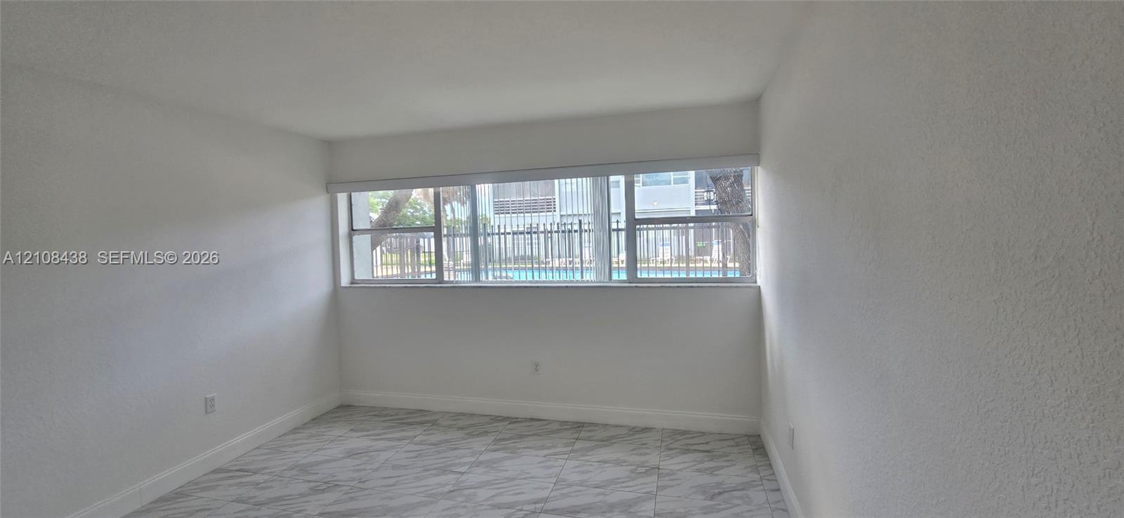 Interior space featuring large-format tile flooring and expansive horizontal windows