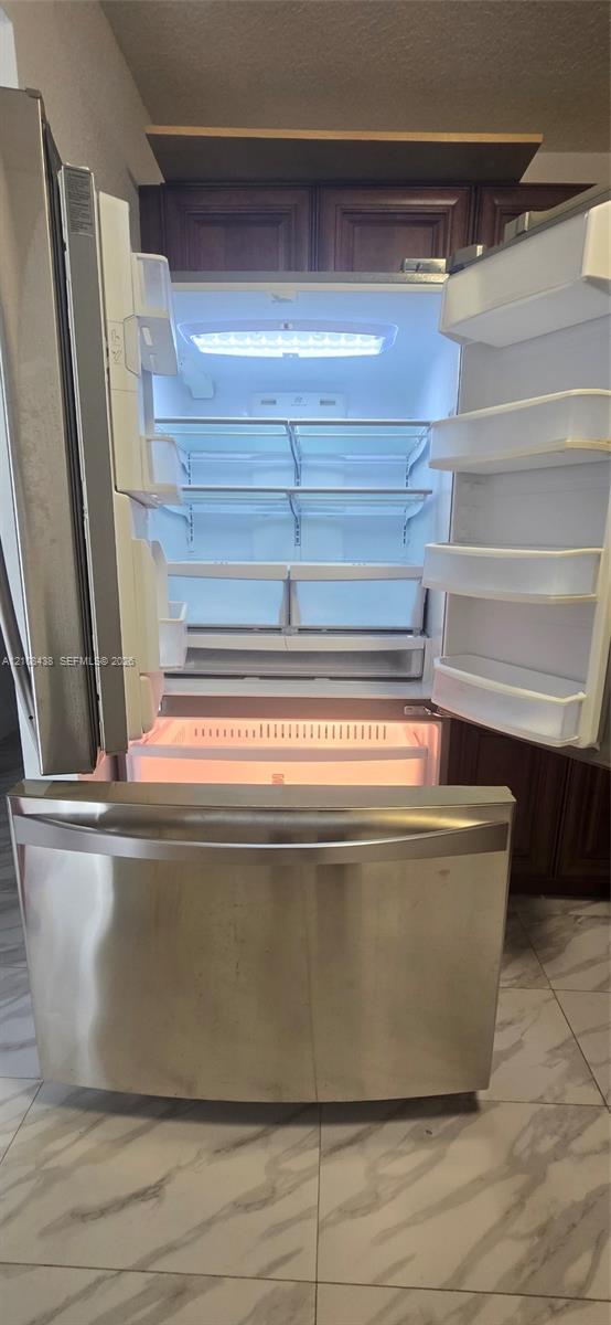 Stainless steel French-door refrigerator featuring an integrated bottom-mount freezer, adjustable interior shelving, and LED lighting